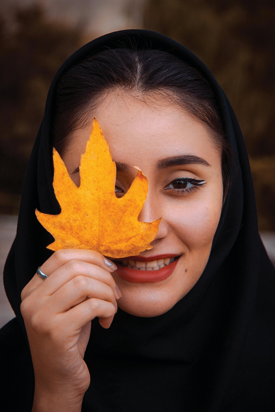 A UAE girl holding a leaf to her face