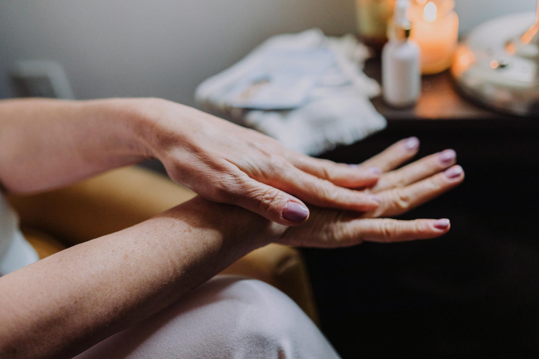 a woman applying lotion on her dry hands