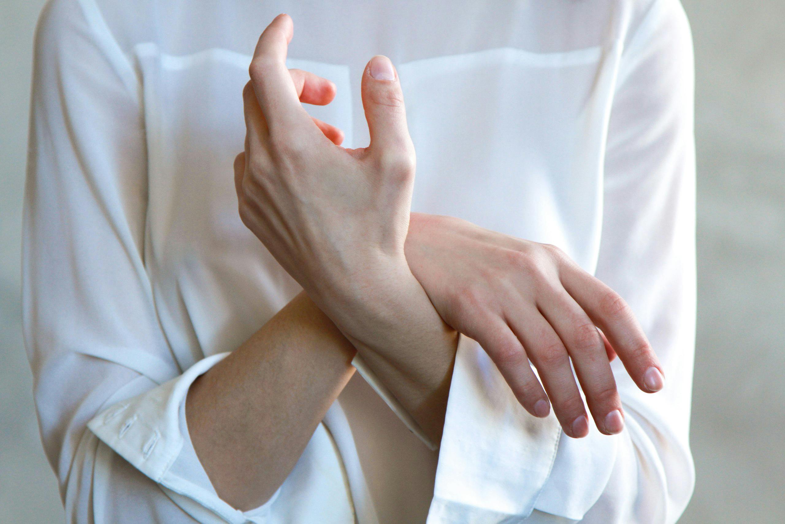 a girl wearing white blouse. holding her hands.