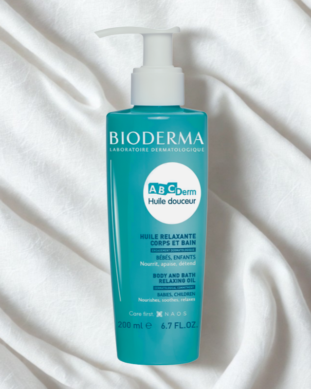 Bioderma ABCDerm bottle on a white fabric background