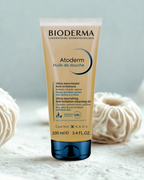 Bioderma Atoderm shower gel tube on a textured surface with a light background