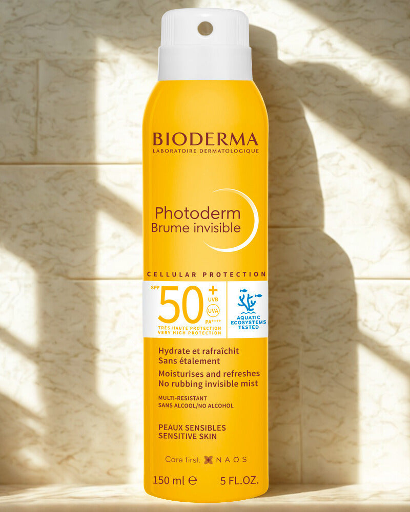 Bioderma Photoderm Brume Invisible spray bottle on a textured stone background