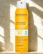 Bioderma Photoderm Brume Invisible spray bottle on a textured stone background