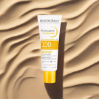 Bioderma Photoderm Fluide MAX sunscreen tube on a textured beige background