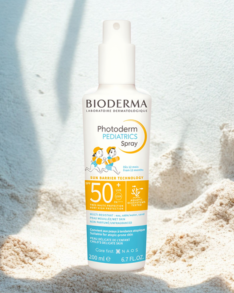 Bioderma Photoderm Pediatrics Spray bottle on a sandy background