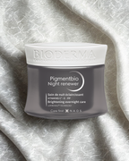 Bioderma Pigmentbio Night Renewer jar on a textured gray background