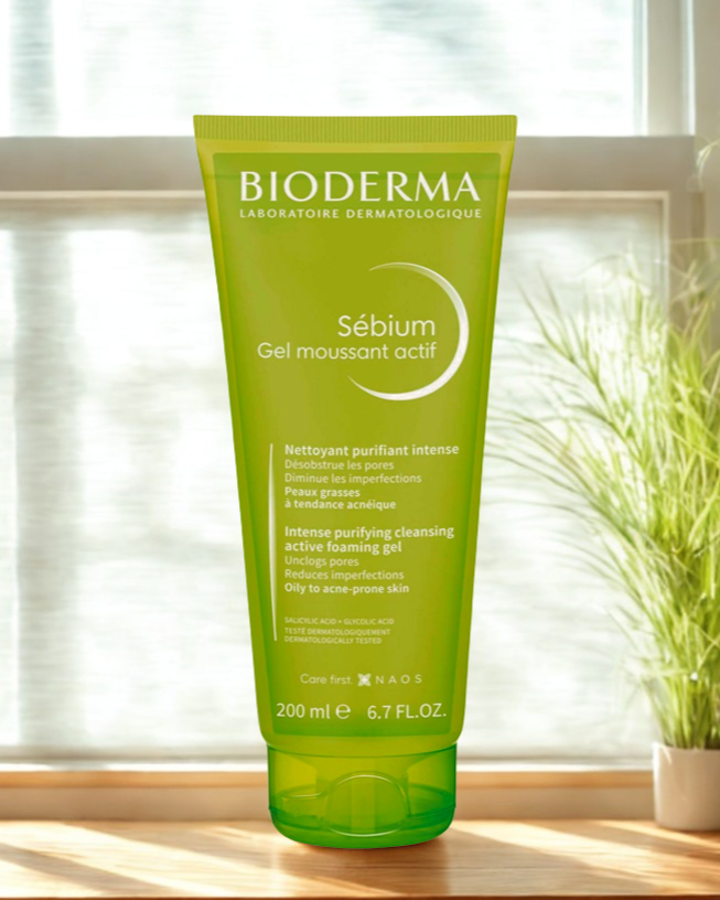 Bioderma Sebium gel moussant actif tube on a windowsill with a plant in the background