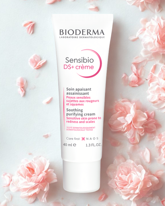 Bioderma Sensibio DS+ crème tube surrounded by pink flowers on a light background