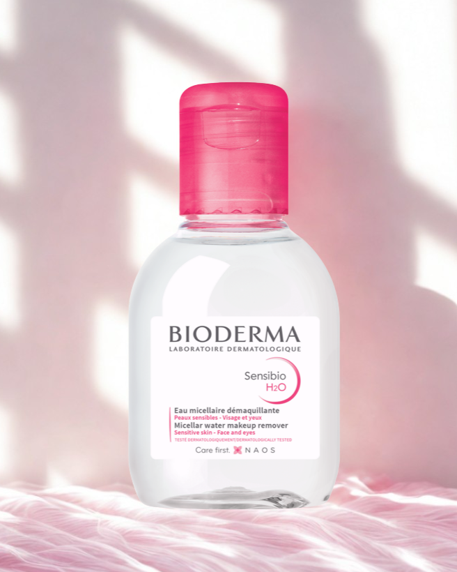 Bioderma Sensibio H2O bottle with pink cap on a soft pink background
