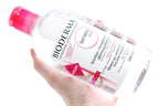 Bioderma Sensibio bottle held in a hand against a white background