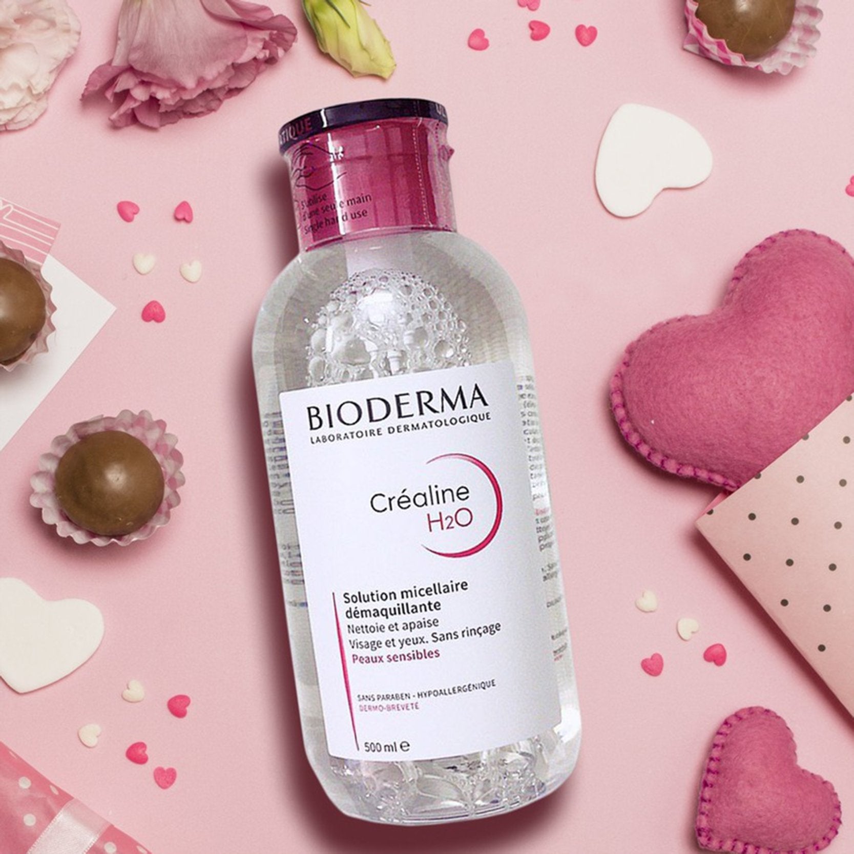 Bioderma bottle on a pink background with decorative elements