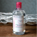 Bioderma bottle with pink cap on a textured surface