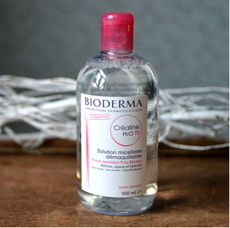Bioderma bottle with pink cap on a textured surface