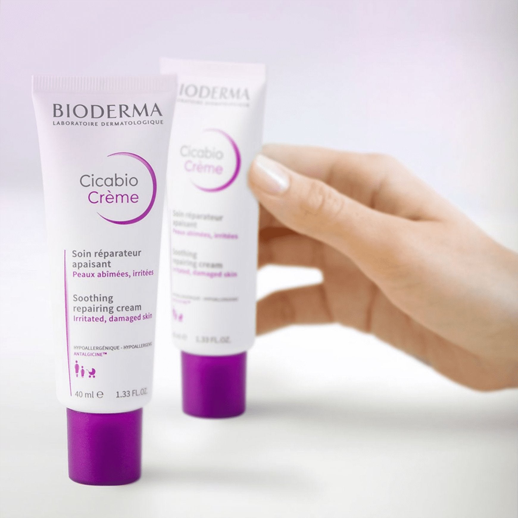 Two Bioderma Cicabio Creme tubes held by a hand on a light background